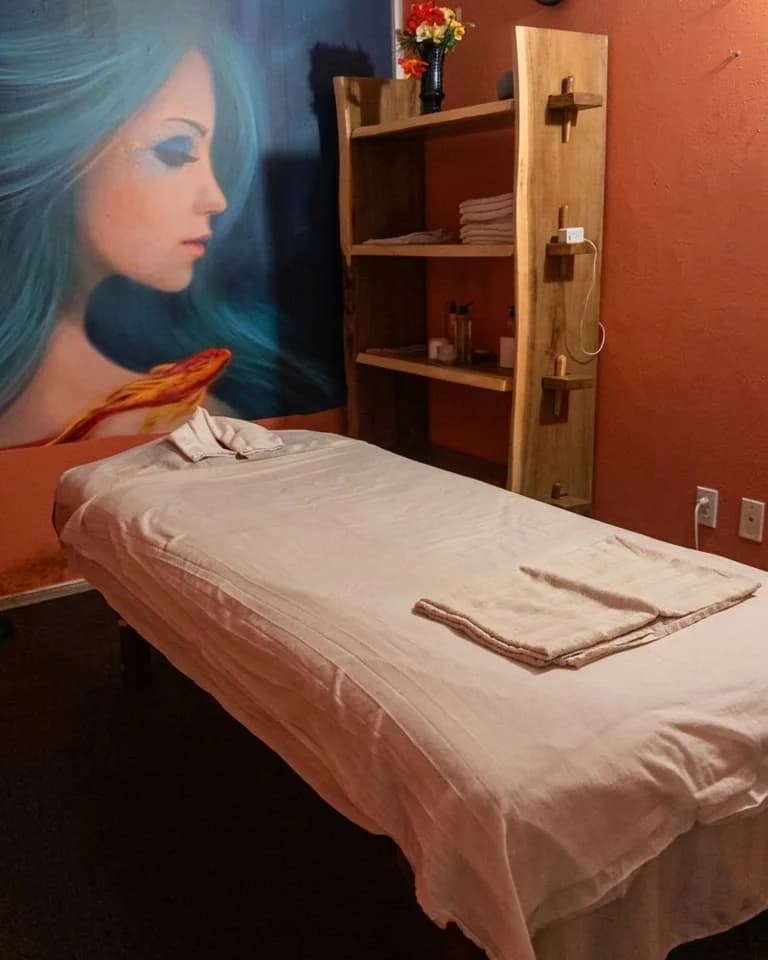 Private massage room with a large mural and wooden shelves